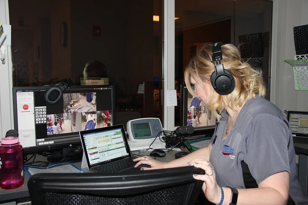 Health Science instructor programming the scenario for training in the simulation center.